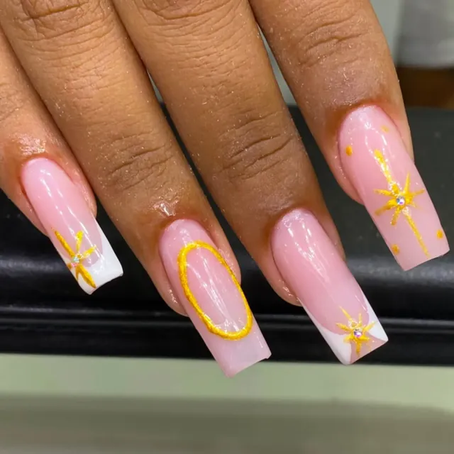 Alongamento de unhas rosadas com nail art de estrelas douradas e strass